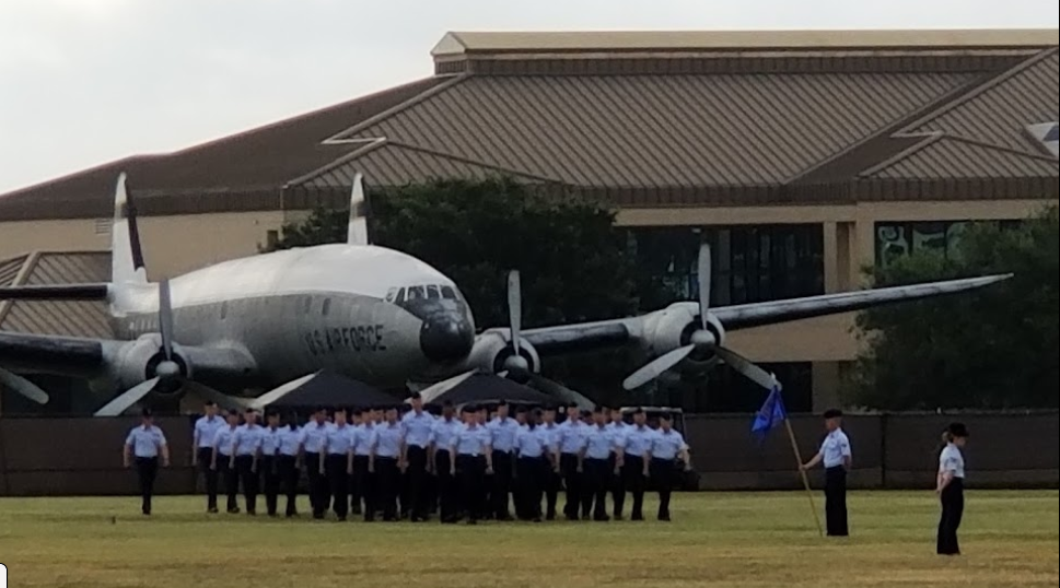 a group of people standing in front of an airplane at Lackland Air Force Base